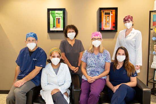 Doctor and staffs wearing masks in group picture at Stephen L Ruchlin DDS 