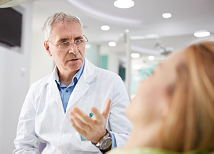 Smiling dental professional consulting a patient, at Stephen L Ruchlin DDS.