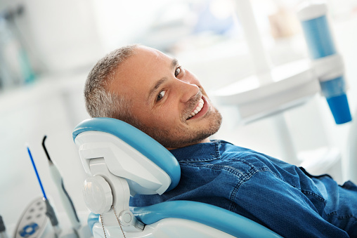 Image of a patient smiling before a dental professional provides an oral appliance therapy device at Stephen L Ruchlin DDS in Rochester, NY.